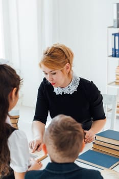 teacher at lesson at school with children and books