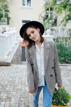woman in a hat on a walk near the house