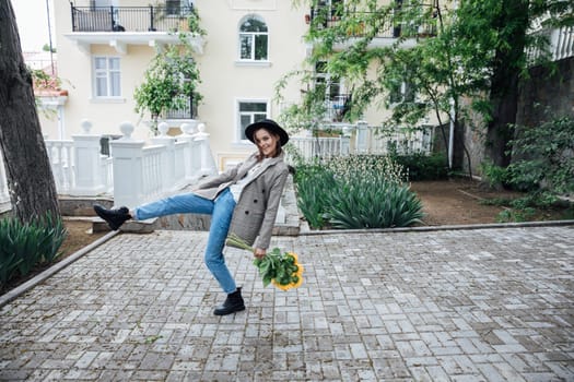 Woman in a hat with flowers posing for a walk