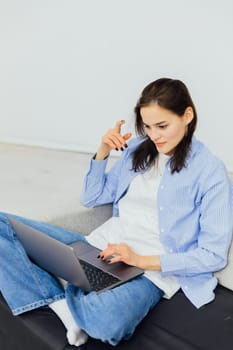 Woman sitting on couch with noitbook online