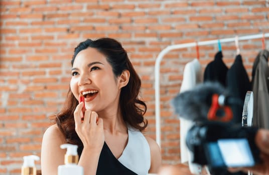 Woman influencer shoot live streaming vlog video review makeup uttermost social media or blog. Happy young girl with cosmetics studio lighting for marketing recording session broadcasting online.