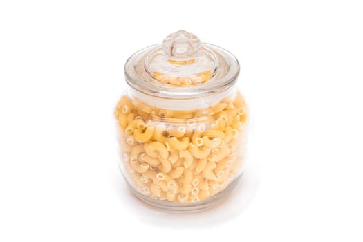 Uncooked Chifferi Rigati Pasta in Glass Jar Isolated on White Background. Fat and Unhealthy Food. Classic Dry Macaroni. Italian Culture and Cuisine. Raw Pasta - Isolation