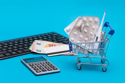 Ordering Medicines. Expensive Medicine and Inflation Concept: Pills and Capsules in a Shopping Cart on Blue Background. Global Pharmaceutical Industry and Big Pharma. Trade in Medicines