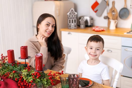 Fun mom and son playing in kitchen, happy spending time on Christmas Eve and New Year's Eve