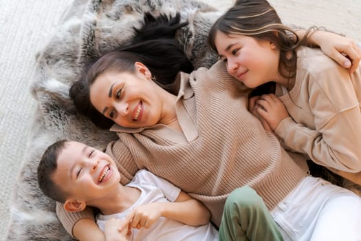 Mom and kids lying on bed in decorated bedroom and laughing concept winter holidays with the family