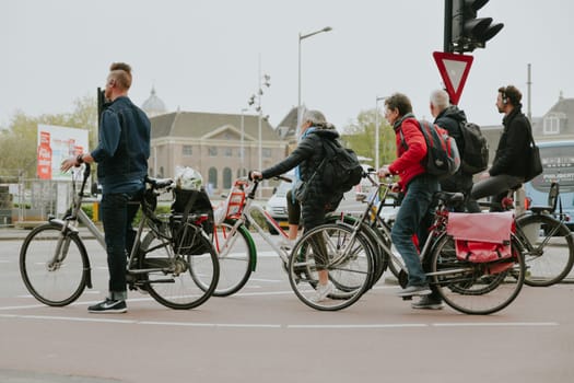 AMSTERDAM, THE NETHERLANDS - APRIL 16, 2019: The Cyclists on bicycles wait for a green traffic light