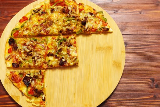 St. Louis-Style Pizza on a plate, cut into squares, on a wooden background. Copy space