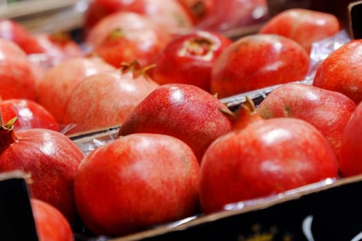 Pomegranate fruit on the shelves of a grocery hypermarket. Selective focus. Buying fruit