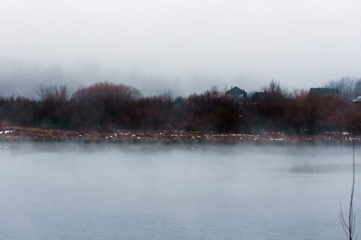 Body of water surrounded by trees and fog. Mysticism nature, tranquility