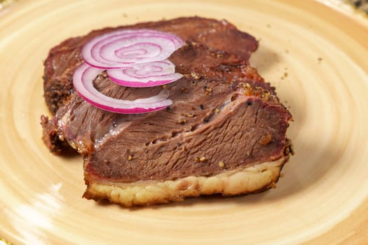 Beef steak close-up with onions. Concept of tasty food. Serving dishes in the restaurant. Selective focus