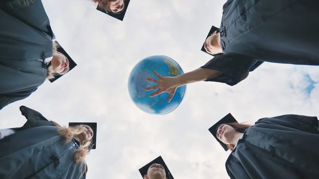 The concept of a world without war. College graduates holding a geographical globe of the world