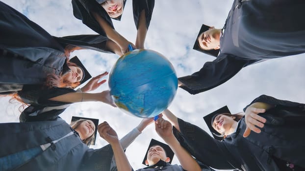 Graduating students twirl a geographic globe of the world in their hands