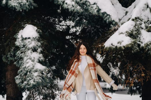 Portrait of a girl with long hair in mittens in a winter forest . Snowy winter.