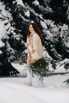 A girl in a winter forest with a bouquet of fir branches. Snowy winter.