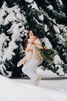 A girl in a winter forest with a bouquet of fir branches. Snowy winter.