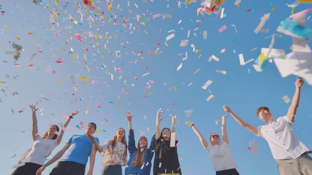 Friends toss colorful paper confetti from their hands