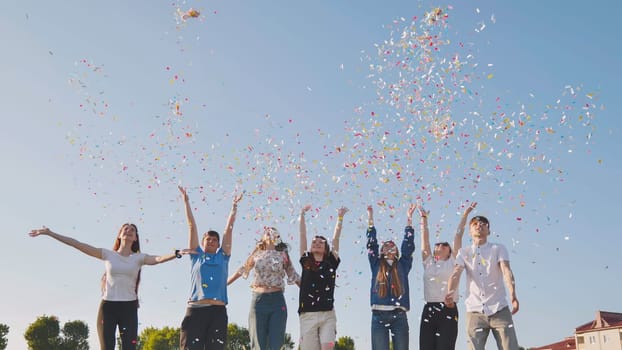 Friends toss colorful paper confetti from their hands