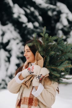 A girl in a winter forest with a bouquet of fir branches. Snowy winter.