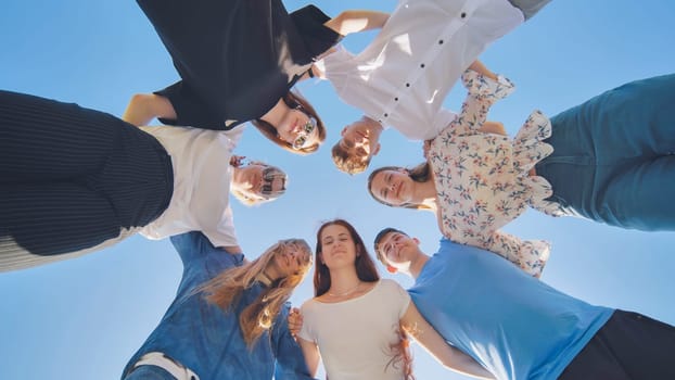 Friends put their heads together in a circle on a summer afternoon