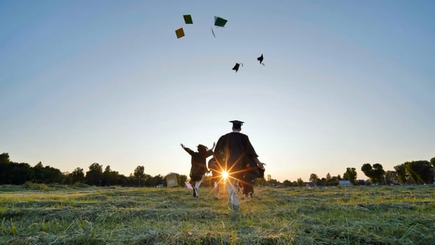 Cheerful graduates students run throwing notebooks after school at sunset