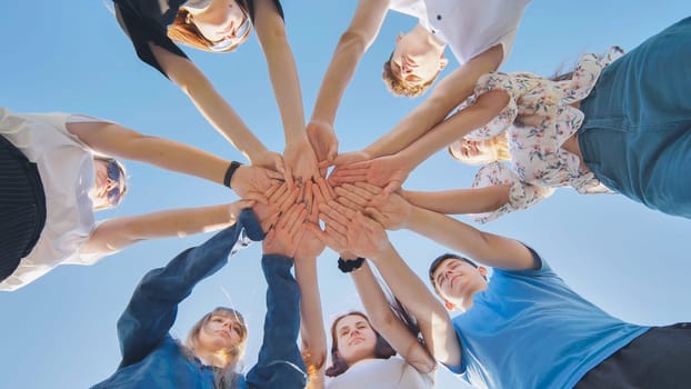 Friends putting their hands together in a sign of unity and teamwork. Just the hands