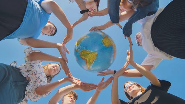 Students make a circle around the globe of the world. The concept of world peace