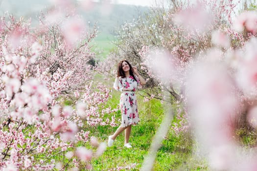 spring nature walk beautiful woman brunette in flowering trees