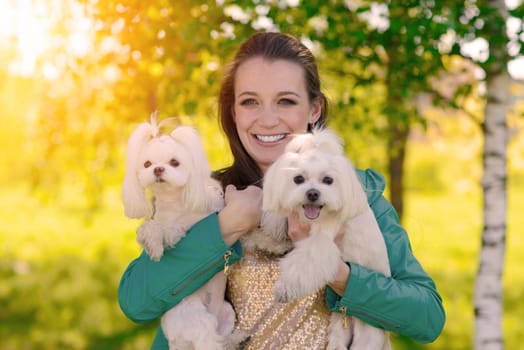 Young woman with her dog. Puppy white dog is running with it's owner. Concept about friendship and animal.