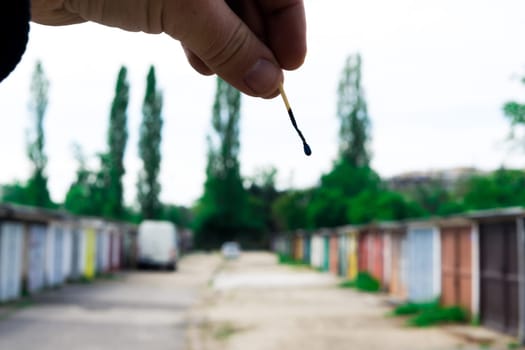 A match, a hand with matches against the background of old garages in city.