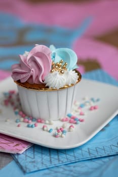 Cupcake blue and pink for gender party. boy or girl. delicious cupcakes with blue and pink cream, golden sparkles celebration concept when the gender of the child becomes known. Festive baby shower sweets concept close up