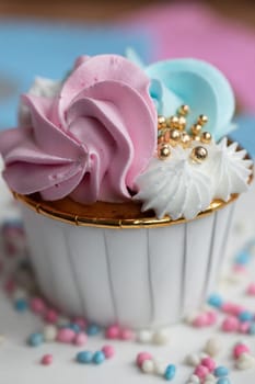 Cupcake blue and pink for gender party. boy or girl. delicious cupcakes with blue and pink cream, golden sparkles celebration concept when the gender of the child becomes known. Festive baby shower sweets concept close up