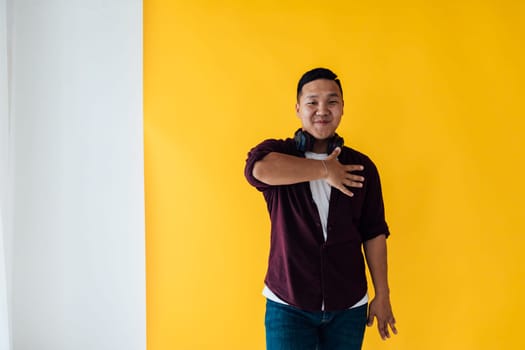 A man with headphones dancing on a yellow background