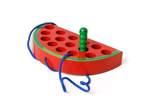 Kid's wooden Montessori toy in the shape of a red watermelon with a funny worm on a rope, toy for fine hand motor skills, isolated on white background