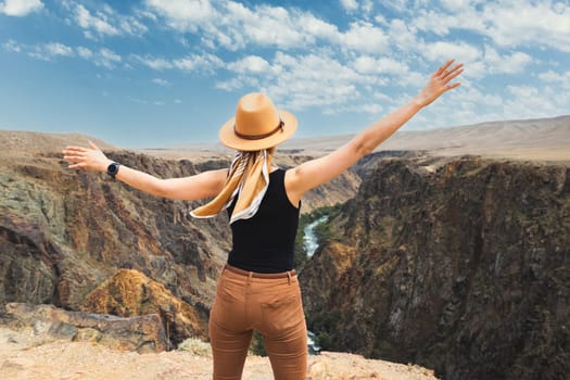 A woman tourist delighted with upper part of the Charyn River, which flows through the Charyn Canyon in Kazakhstan in the Almaty region.