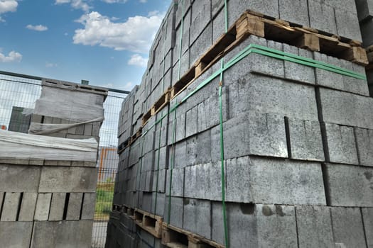 Big gray concrete bricks on pallets on a construction outdoor store.