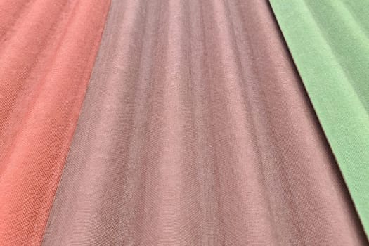 Close up on three sheets of ondulin of different colors. Modern cheap roofing material.