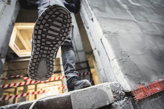 Tread construction safety shoes on a worker walking on a construction site.