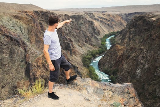 Man tourist stand and look on upper part of the Charyn River, which flows through the Charyn Canyon in Kazakhstan in the Almaty region.