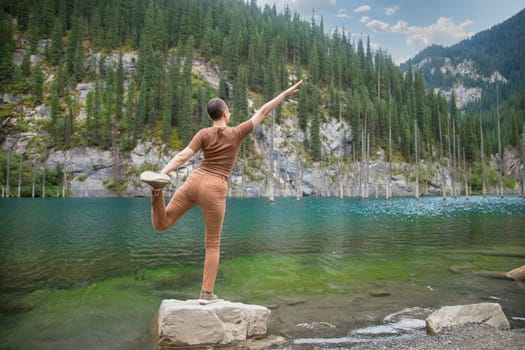 Woman retreat on Kaindy lake. Picturesque nature of Kazakhstan in Almaty region.