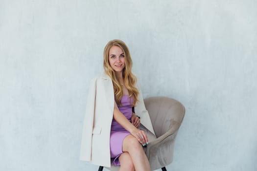 Portrait of beautiful blonde woman in dress and jacket