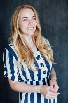 Beautiful blonde woman in light summer striped dress