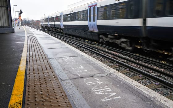 London, United Kingdom - February 01, 2019: National rail train arriving at Lewisham station on overcast day, mind the step written on platform.