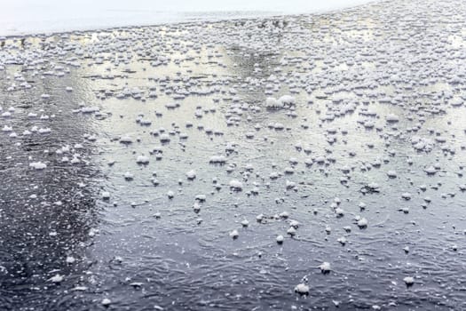 Flat ice on frozen pond, with small patches of crystalline snow.