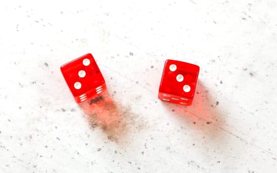 Two red craps dices showing Hard Six (double number three) overhead shot on white board