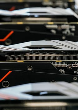 Selective focus photo (only metal cooler in focus), row of video graphics cards on computing rig. Abstract cryptocurrency mining background