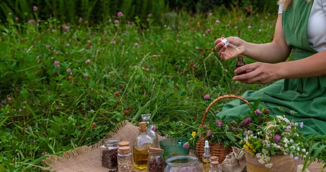 A woman makes herbal tincture. Selective focus. Nature.