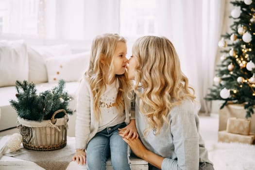 Happy family: mother and daughter. Family in a bright New Year's interior with a Christmas tree