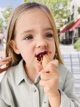 Little girl eats ice cream in a waffle cone. High quality photo