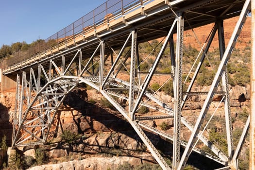 Side View Metal Construction Of Bridge Supports, Infrastructure. Blue Sky And Mountain. Rivets And Braces On Metal Beams. Midgley Bridge, Sedona Arizona, Coconino County. Oak Creek Canyon High quality photo