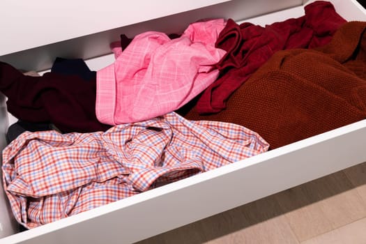 Messy Drawer With Dangling Unfolded Man's Clothes, Scattered Things, Junk Drawer. Organizing Wardrobe, Closet. Clean That Mess Concept, Organize Your Dresser, Storage Solutions, Horizontal Plane.